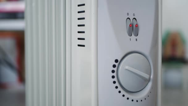 Мужчина отключил переносной электрический обогреватель в домашней комнате — стоковое видео