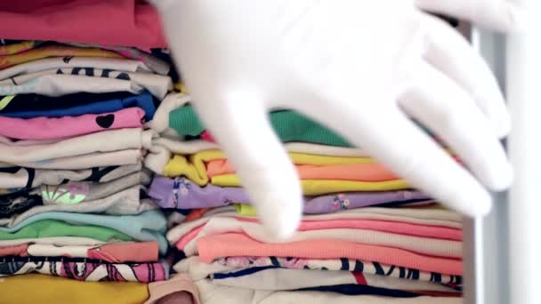 Man 's Hand Otwiera drzwi szafy z czystymi ubraniami złożonymi na półkach — Wideo stockowe