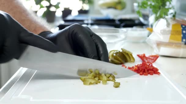 Persona vegana in cucina che taglia un cetriolo sottaceto per insalata — Video Stock