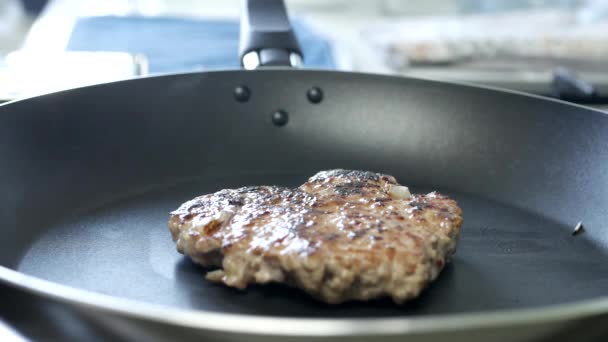 Osoba w Kuchni smaży hamburgera na gorącej patelni — Wideo stockowe