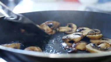 Dilimlenmiş mantarlar Mutfakta kızgın tavada yağda kızartılıyor.