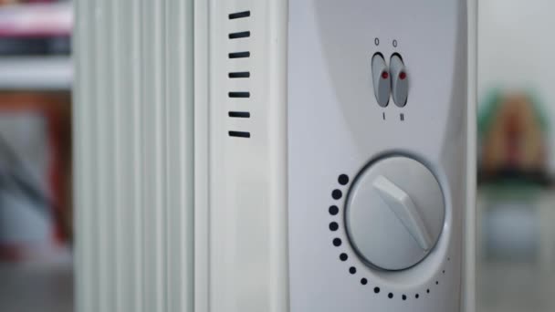 De mens stelt de temperatuur van de verwarming van een elektrische radiator thuis — Stockvideo