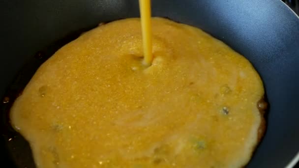 Příprava míchaných vajec smíchaných s kukuřičnou moukou v horké pánvi na sporáku — Stock video