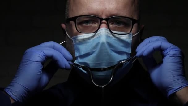 Γιατρός Προστατευμένος με Μάσκα Προσώπου και Γάντια Προστασίας Ενάντια στο COVID-19 Χρησιμοποιώντας ένα στηθοσκόπιο για Ιατρική Διαβούλευση σε Αναπνευστική Νόσο — Αρχείο Βίντεο