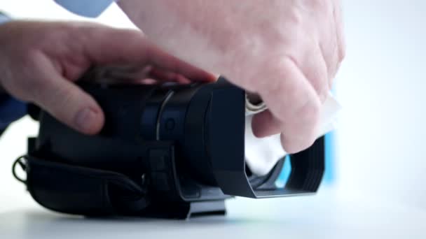 Fotógrafo Limpie la lente de la cámara Preparándose para una sesión de grabación de vídeo — Vídeo de stock