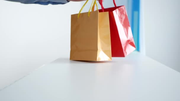 Hombre Compras pequeños regalos en dos coloridas bolsas de regalo — Vídeos de Stock
