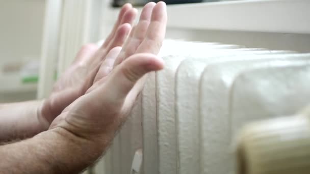 Mrożone osoby w domu Spróbuj ogrzać ręce w pobliżu kaloryfera — Wideo stockowe