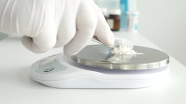 Bir araştırma etkinliğinde, bir bilim adamı tıbbi endüstri için elektronik ölçekli ilaç tozu kullanır.