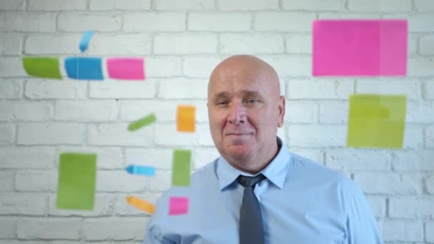 Affärsman Le Nöjd bakom en genomskinlig styrelse med färgade klisterlappar i mötesrummet — Stockvideo