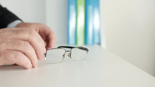 Empresário no escritório em uma reunião de negócios com seus óculos na mesa — Vídeo de Stock