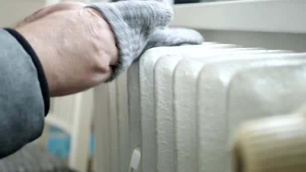 Pessoa congelada Coloque luvas de malha nas mãos e tente se aquecer perto de um radiador — Vídeo de Stock