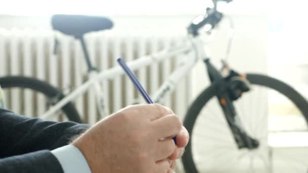 Un homme d'affaires assis sur une chaise fait des gestes nerveux avec un stylo à la main — Video