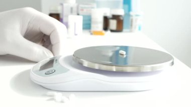 Bir araştırma etkinliğinde, bir bilim adamı laboratuardaki elektronik ölçeği kullanarak bazı tıbbi hapları tartar.