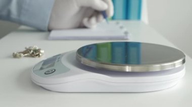 Bir Kuyumcuda Kuyumcu Bulanık Masada Elektronik Ölçek ve Notlar Kullanarak Altın Mücevherler Ağırlığında