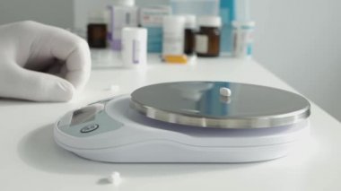 Bir araştırma etkinliğinde, bir bilim adamı laboratuardaki elektronik ölçeği kullanarak bazı tıbbi hapları tartar.
