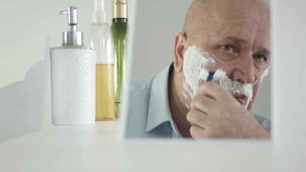 L'uomo d'affari al mattino guarda nello specchio del bagno e si rade la barba — Video Stock