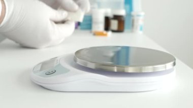 Bir araştırma etkinliğinde, bir bilim adamı tıbbi endüstri için elektronik ölçekli ilaç tozu kullanır.