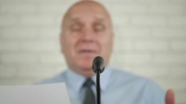Elmosódott kép egy üzletember hangszóró egy sajtótájékoztatón Beszél a mikrofon és a Gesturing — Stock videók
