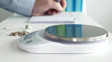 Rehin Dükkanındaki Adam Altın Zincirle Elektronik Ölçek ve Notları Bulanık Masada Kullanıyor