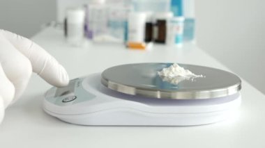 Bir araştırma etkinliğinde, bir bilim adamı tıbbi endüstri için elektronik ölçekli ilaç tozu kullanır.
