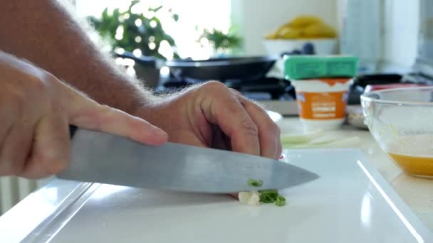 Man in de keuken hakken lente-ui voor salade — Stockvideo