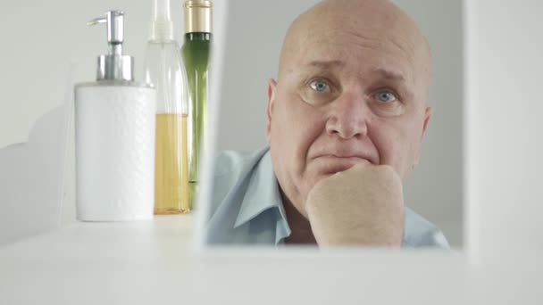 Грустный человек, стоящий перед зеркалом в ванной, думая разочарованный и разочарованный — стоковое видео