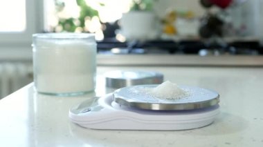 Mutfaktaki Şef Pasta Tarifi için Şekeri Tartmak İçin Elektronik Ölçek Kullanıyor