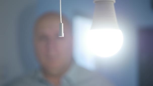 Jedna osoba zmáčkne vypínač a zhasne žárovku v místnosti. Vypnutí LED světla šetří energii. — Stock video
