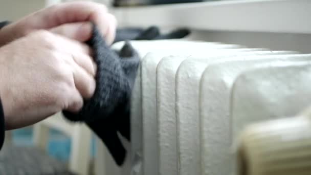Κατεψυγμένα άτομα θέσει πλεκτά γάντια στα χέρια και να προσπαθήσουμε να ζεσταθεί κοντά σε ένα καλοριφέρ — Αρχείο Βίντεο