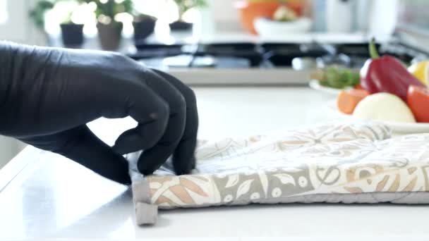 Zblízka natáčení s osobou, která klade na jeho ruce ochranné kuchyňské rukavice — Stock video