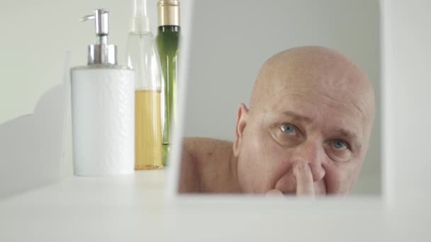 Rano Rutyna, Mężczyzna w łazience patrzy w lustro, dotyka jego oczu i skóry — Wideo stockowe