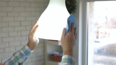Lambayı Islak Peçeteyle Temizleyen Adam ve Sıvı Temizleme Çözümü. Hizmetçi evde ev işleri yapıyor mu?.