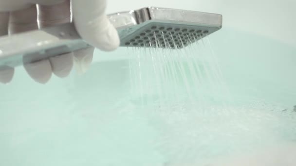 Enfermera con guantes protectores en las manos preparando un baño caliente con cabezal de ducha — Vídeos de Stock