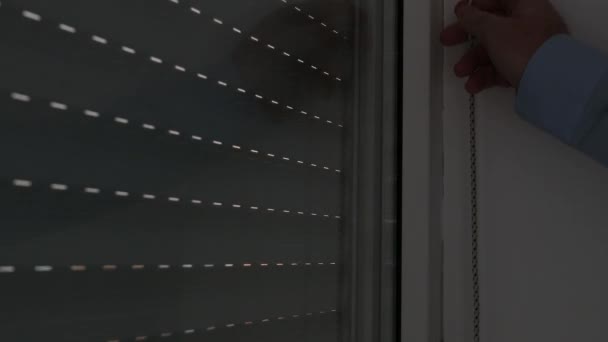 Бізнесмен Руки відчиняють віконні жалюзі в офісній кімнаті. — стокове відео