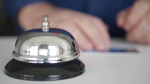 Tourist in a Hotel Reception with a Credit Card in Hand Presses the Bell Button Calling the Receptionist for Payment. — Stock Video