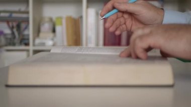 Kütüphanede Edebiyat Kitabı okuyan bir adam. Evde Sözlük Çalışan Öğrenci.