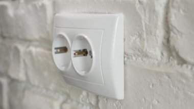 Duvardaki elektrik prizine bir cep telefonu şarj aleti takmak. Bir Outlet 'e bağlı olan bir cep telefonu için elektronik şarj cihazı.