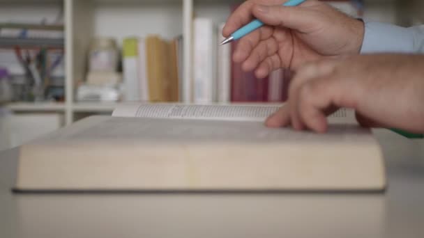 Egy ember a könyvtárban irodalmi könyvet olvas. Student Tanulás egy szótár otthon. — Stock videók