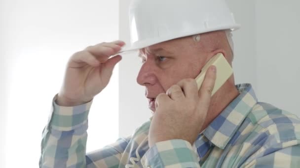 Engenheiro numa sala de apartamentos a falar ao telefone. Trabalhador Heaving uma discussão técnica no telefone fixo. — Vídeo de Stock