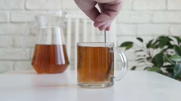 Mão de homem misturando açúcar em uma xícara de chá com uma colher de chá. — Vídeo de Stock
