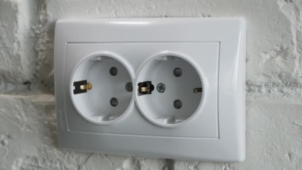 Insertar un cable de alimentación eléctrica en un enchufe en la pared de la oficina. — Vídeo de stock