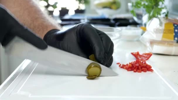 Veganist in de keuken die een gepekelde komkommer hakt voor salade — Stockvideo