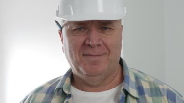 İnşaat endüstrisinde çalışan teknisyen portresi. Çalışan bir röportajda kameraya gülümsüyor.