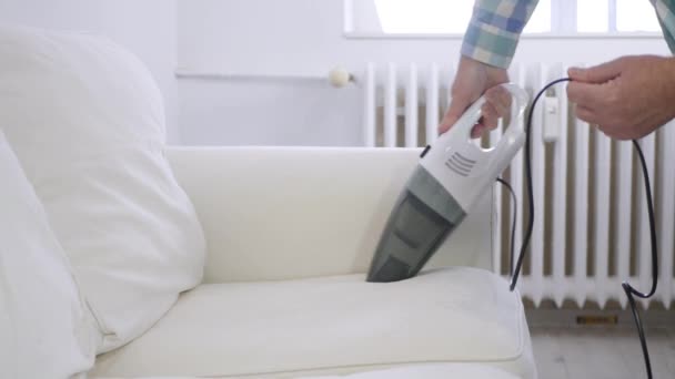 Man Using a Vacuum Cleaner in Household Activities to Clean the Sofa Surface from Dust. — Wideo stockowe