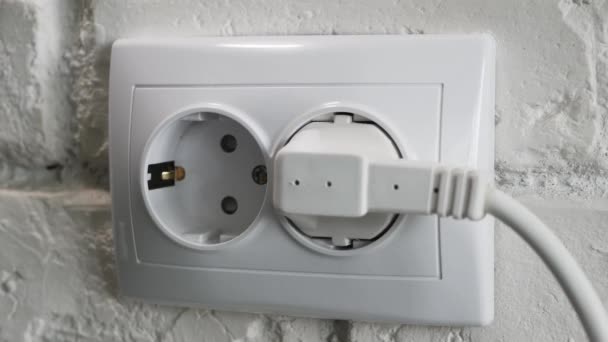 Desligar um cabo de alimentação elétrica de um soquete de parede no escritório. — Vídeo de Stock