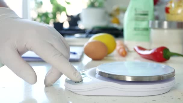 Chef en la cocina pesa una zanahoria fresca usando una balanza electrónica — Vídeo de stock