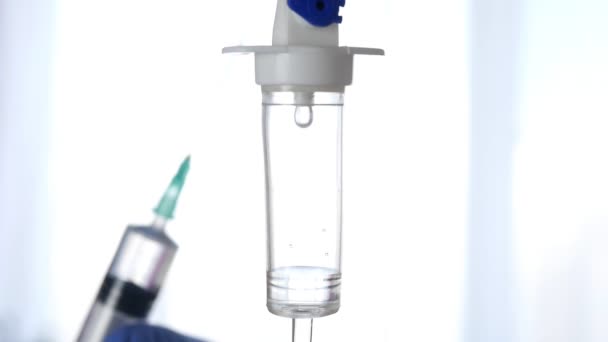 Медичне перфузійне капання і лікар на задньому плані розмиті шприцом з вакциною в руці. повільна стрілянина. — стокове відео
