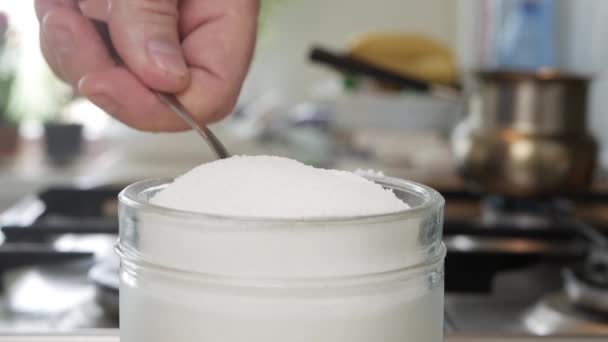 Neem een volle theelepel met witte suiker uit de pot, een zoet ingrediënt voor snoep, cake en drank. — Stockvideo