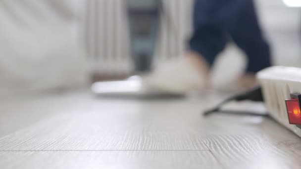 Man med hjälp av en dammsugare i hushållsaktiviteter, Tryck på strömknappen och börja rengöra golvet. — Stockvideo