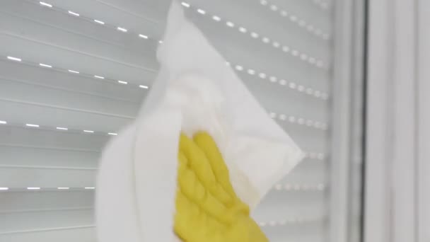 Close Up Manos Protegidas con Guantes Amarillos para el Hogar Limpieza de una Ventana Usando Líquido Desinfectante y Servilletas Limpias. — Vídeo de stock